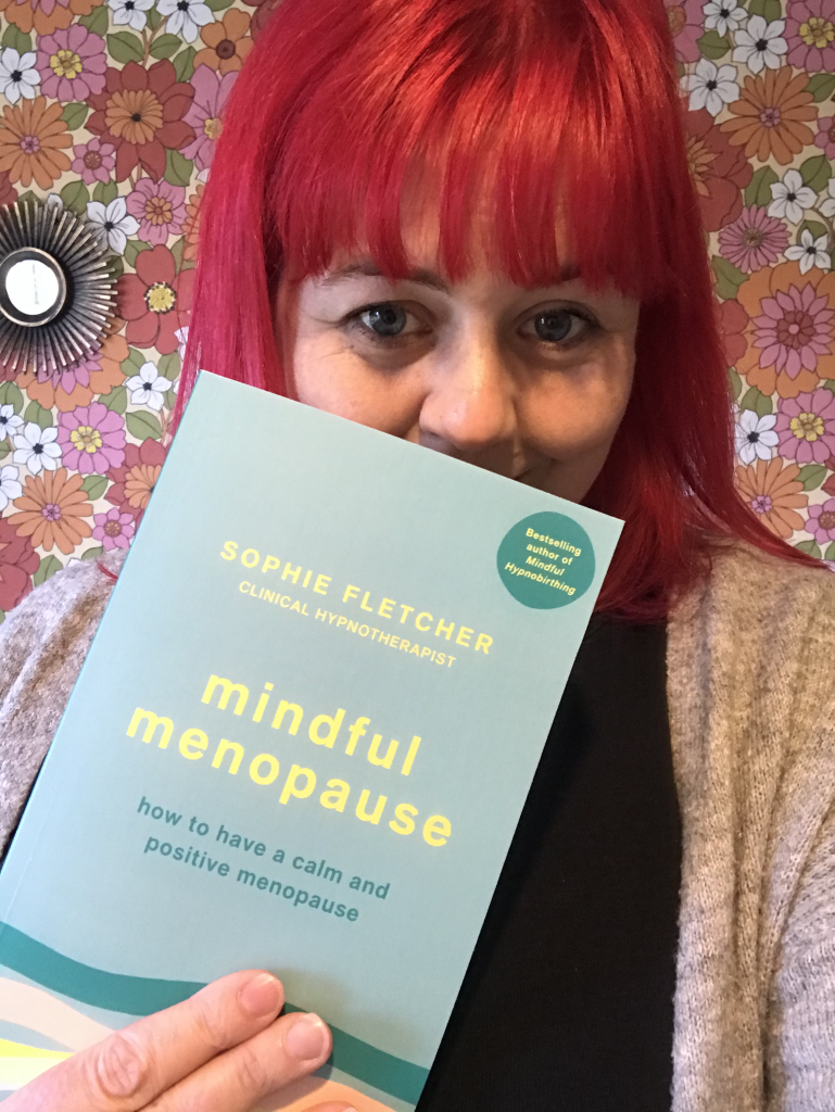 Michele Donnison holding the Mindful Menopause book she illustrated