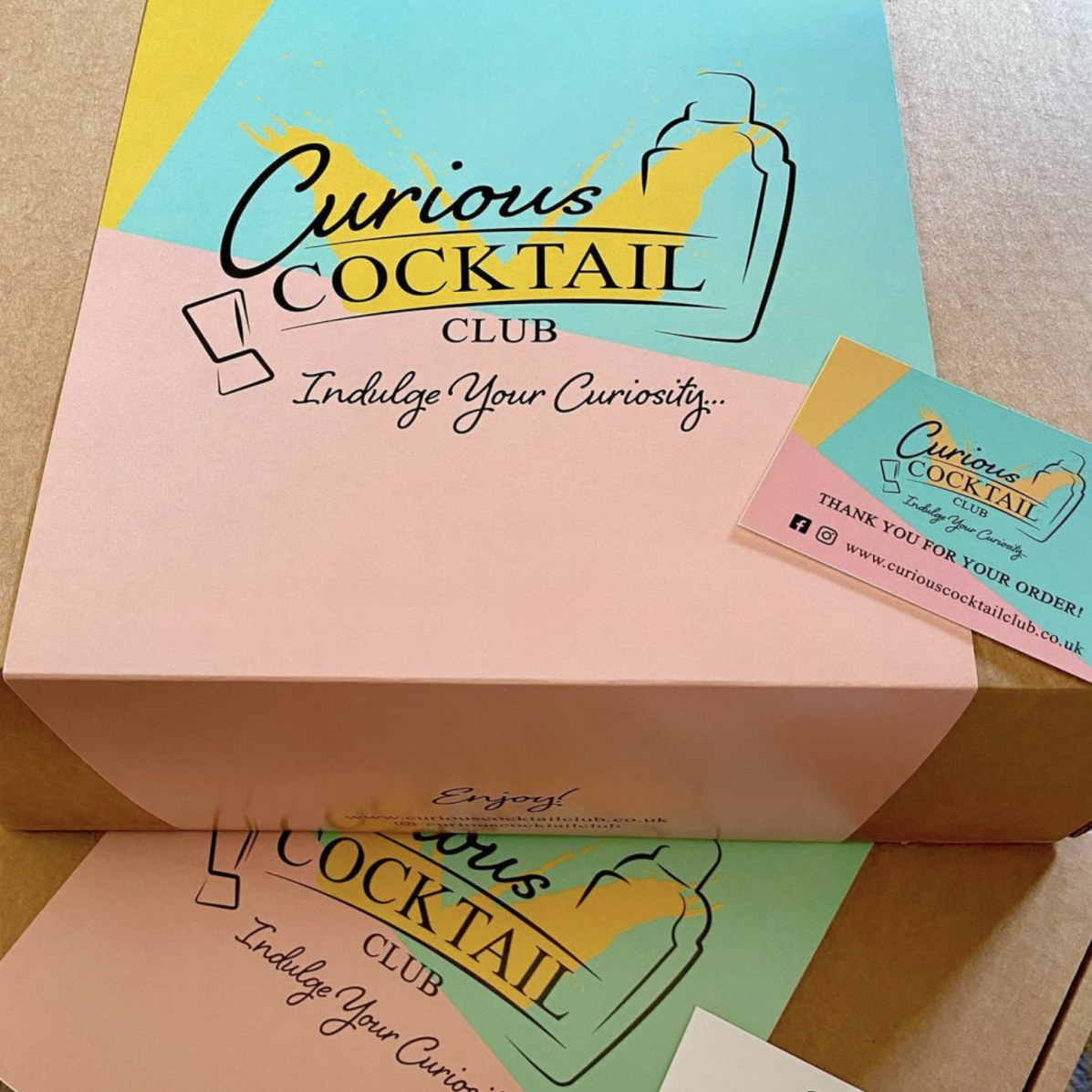 Curious Cocktail Subscription box sleeve design featuring logo design on brand colours - pink aqua and yellow